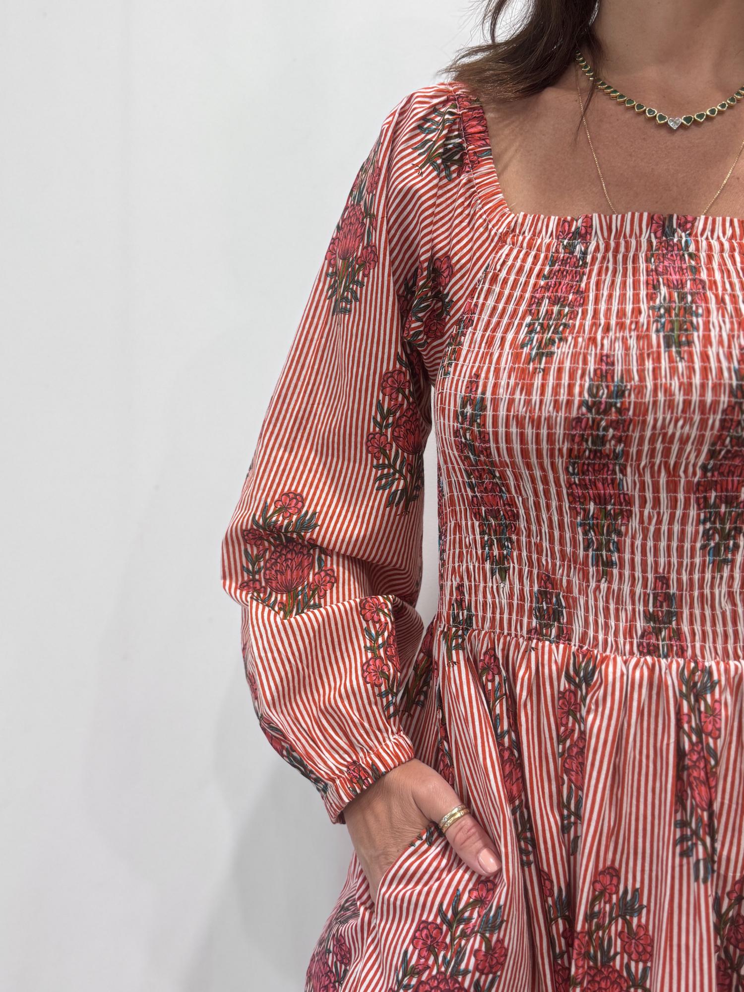 Robe Naya Bordeaux, une robe longue smockée. Fluide et 100 % coton. Elle est rayée avec des imprimés de fleurs.