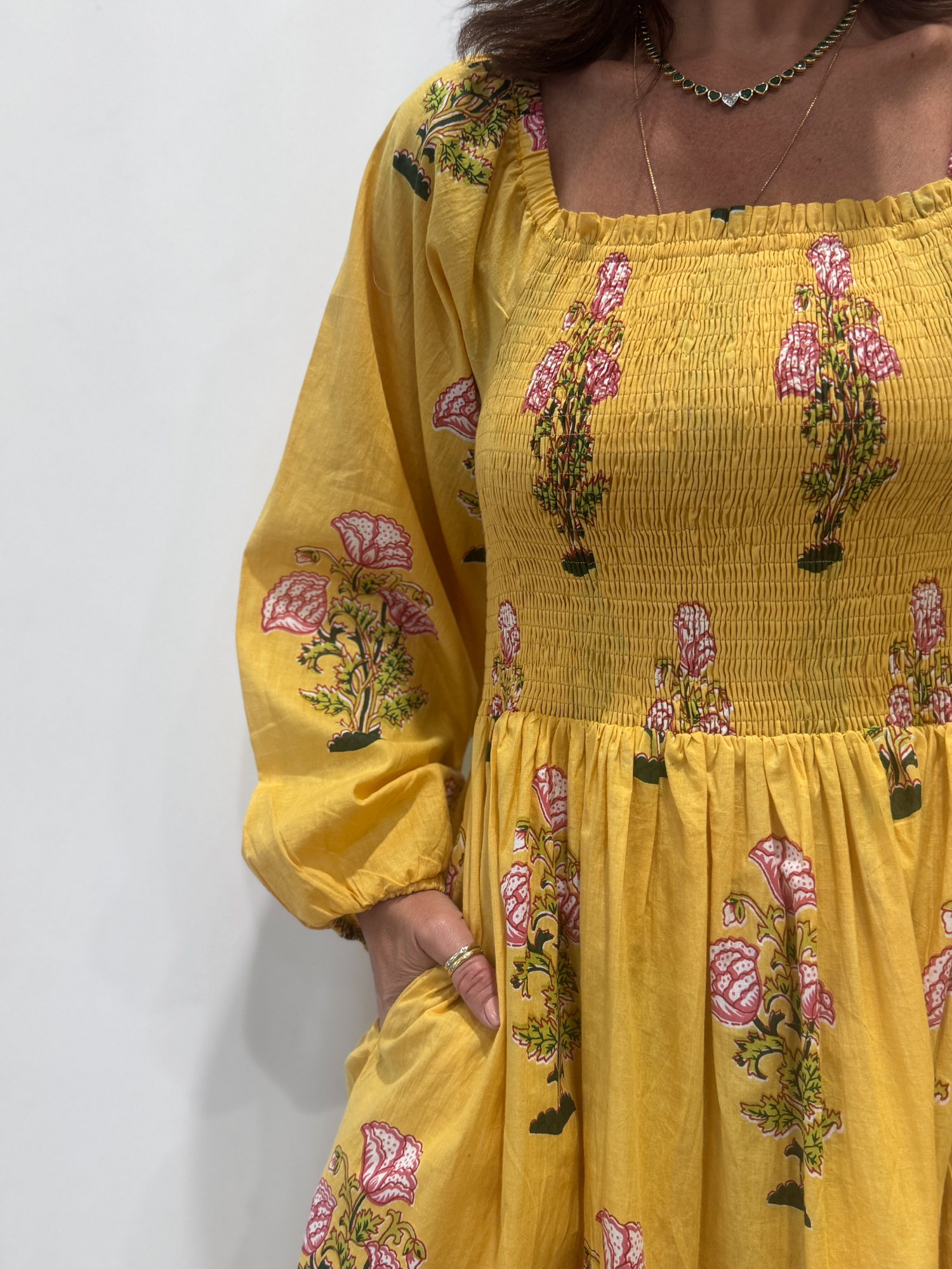 Robe Naya Jaune, une robe longue smockée. Fluide et 100 % coton. Elle est rayée avec des imprimés de fleurs.