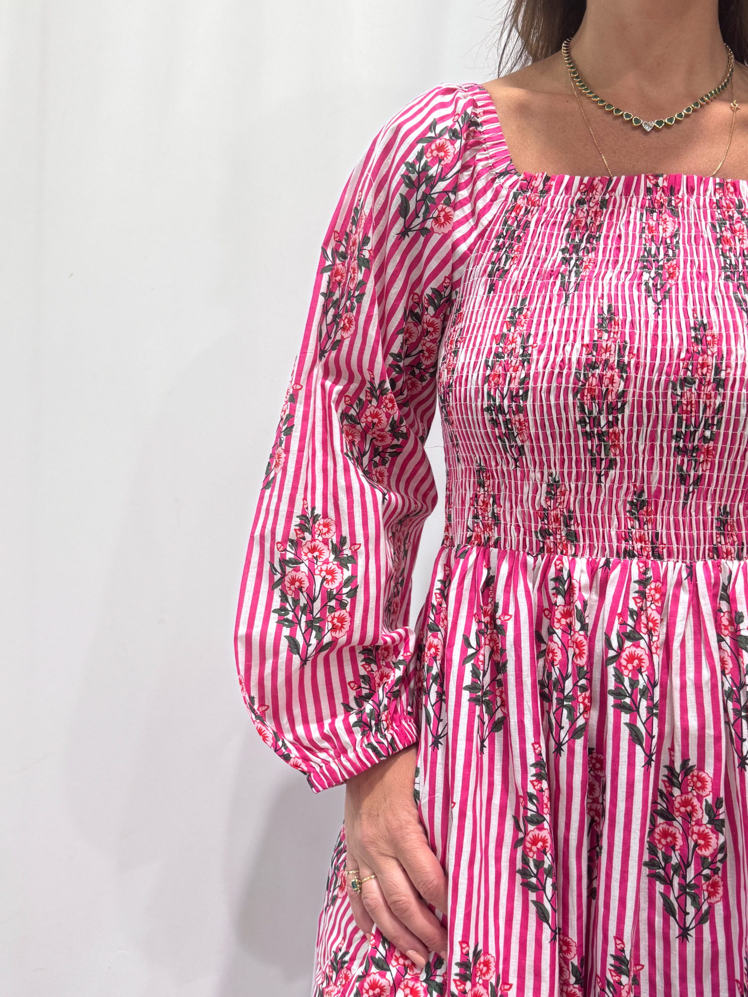Robe Naya Rose Rayée, une robe longue smockée. Fluide et 100 % coton. Elle est rayée avec des imprimés de fleurs.