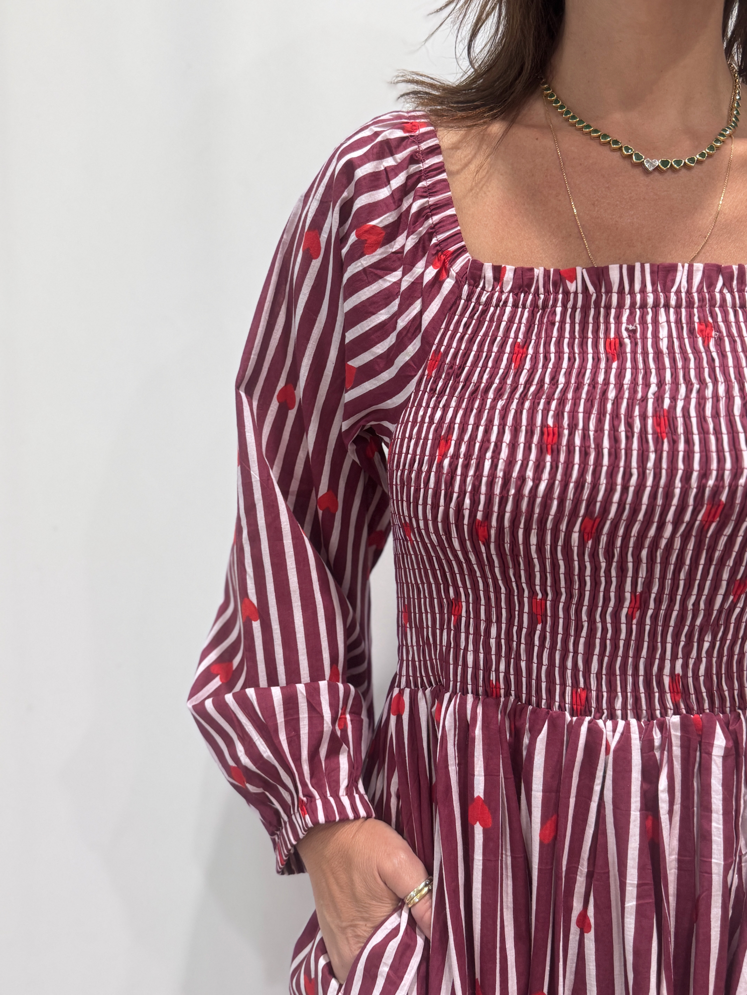 La robe Pyaar Bordeaux, une robe longue manches longues, smockée à rayures et imprimés de coeurs. Une robe tendance pour cet été.