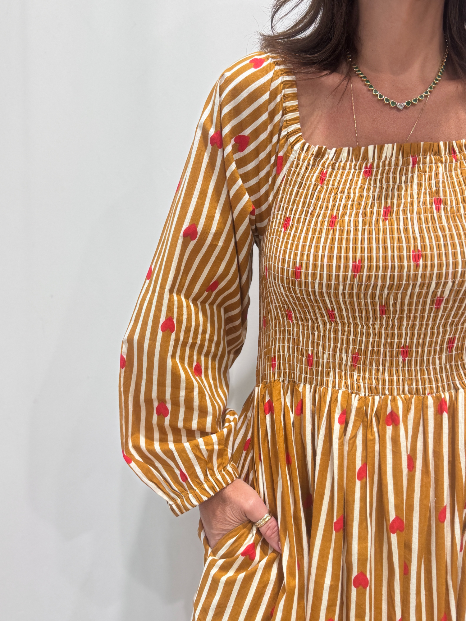 La robe Pyaar Jaune, une robe longue manches longues, smockée à rayures et imprimés de coeurs. Une robe tendance pour cet été.