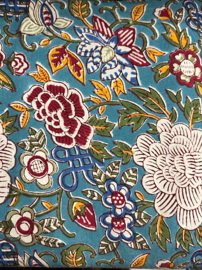 La nappe Amalia une nappe de 180x280 et une nappe sur fond bleu avec des imprimés floraux bordeaux, jaunes et verts. Une nappe pleine de caractère.