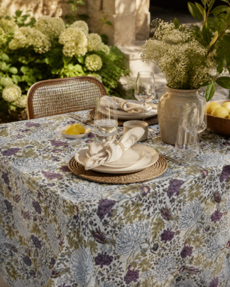 La nappe Adita, une nappe de 180x280 et une nappe sur fond blanc avec des imprimés floraux mauves, bleus et verts. Une nappe douce et élégante.