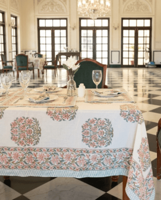 La nappe Juhi, une nappe sur fonc blanc avec des imprimés floraux bleus et oranges.